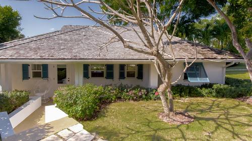 Cottage exterior framed by palms